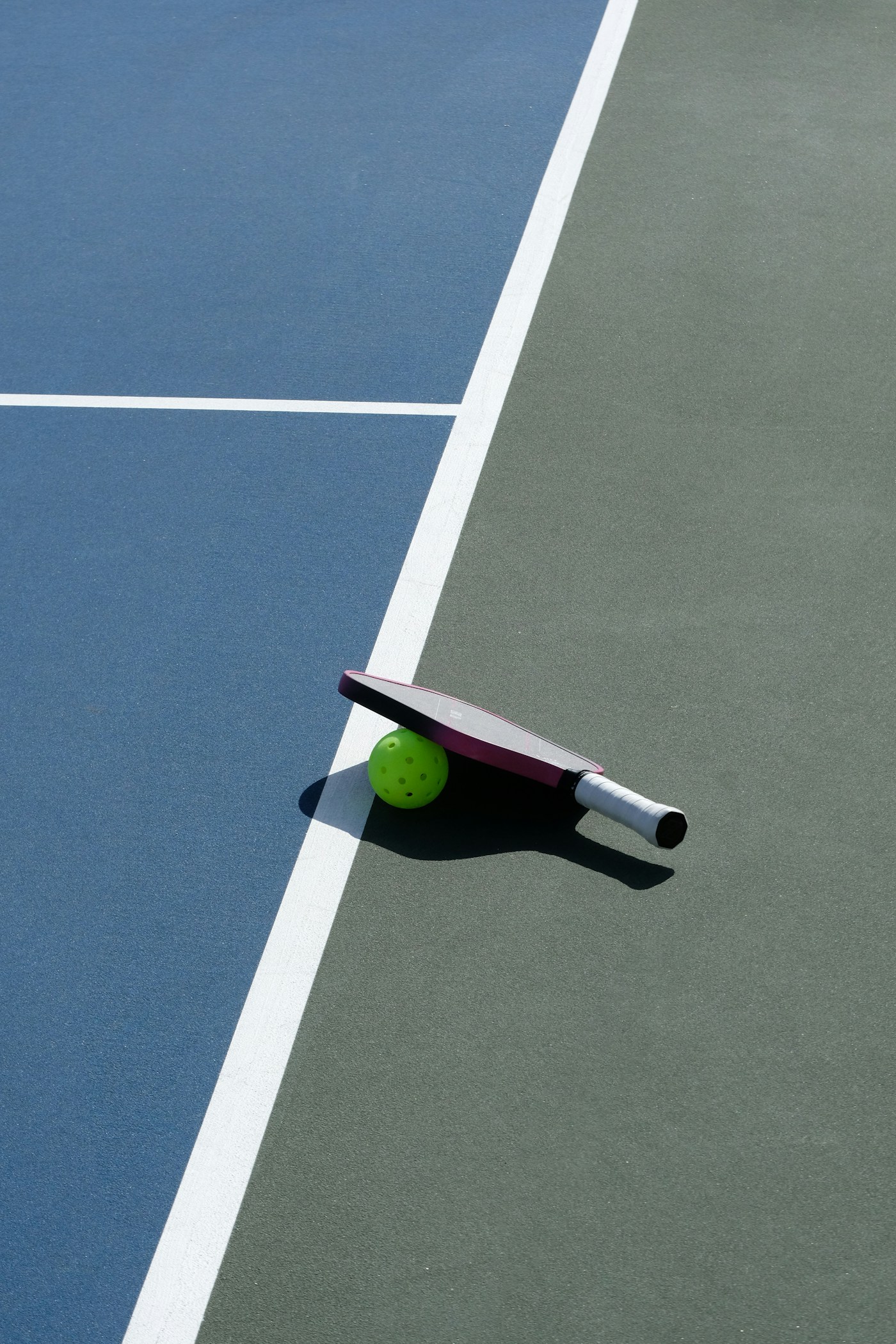 Pickleball paddle and ball on a court surface